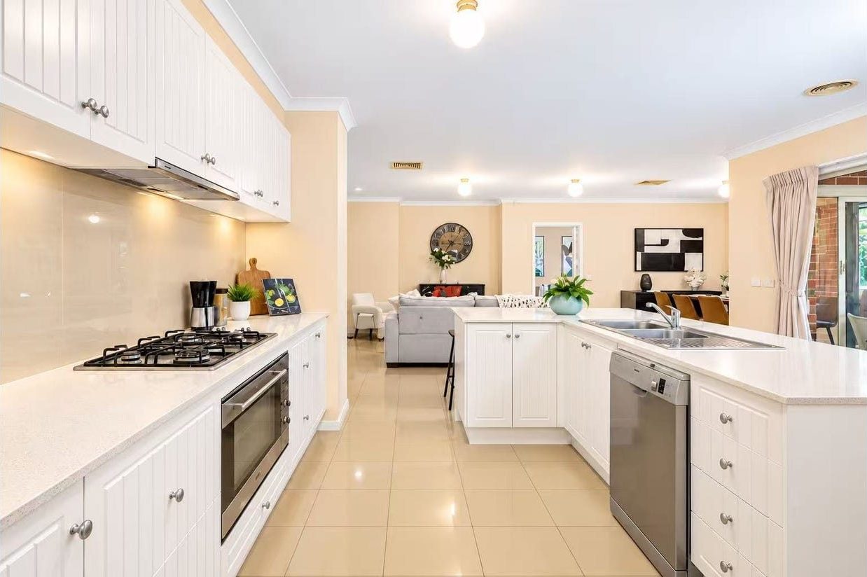 Modern white kitchen with 900mm gas cooktop, Caesarstone benchtops, integrated dishwasher and European appliances at 9 Gilmore Grove